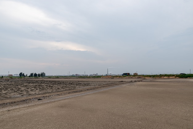 A road piled up on saline alkali land, a salt pond