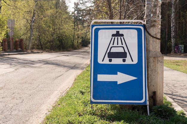 Photo a road sign indicating a car wash installed by a road in the suburbs