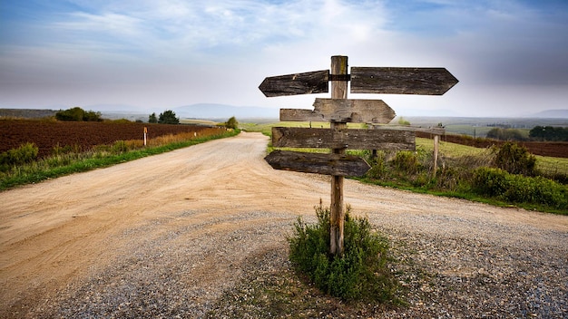 a road sign pointing to the right with a view of the mountains in the background