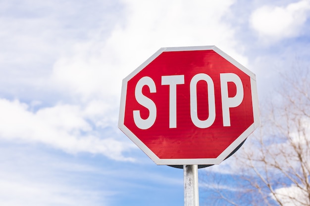 Road sign stop on a cloudy sky