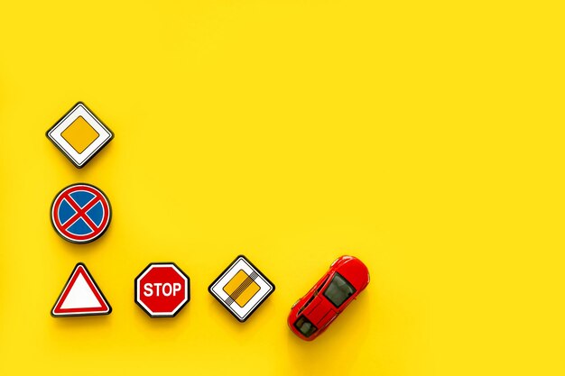 road signs with car on yellow background with copy space