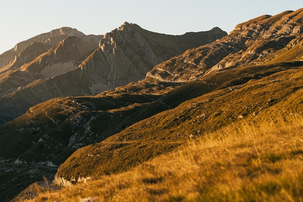 The road that goes between the mountains The setting sun shines on the peaks of the mountains