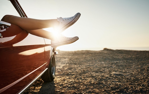 Photo road trip car and feet out window with sunset for travel summer vacation or holiday adventure outdoor relax and person with shoes for destination journey or weekend getaway in california