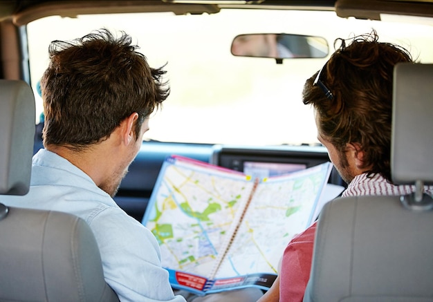 Road trip map and people for travel adventure journey and holiday with tourism guide check and planning Driver men or young friends with location search direction and destination from behind