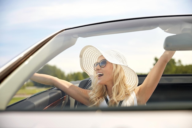 road trip, travel, dating, couple and people concept - happy man and woman driving in cabriolet car outdoors