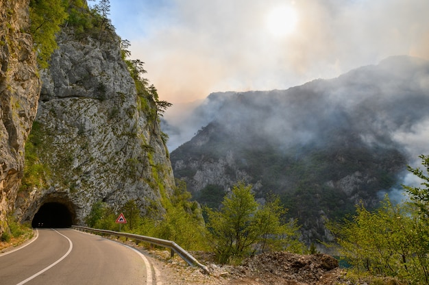 Road and tunnel at piva lake in national park dormitor of montenegro during wildfire at the end of s...