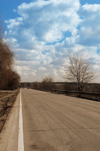 A road with a blue sky and clouds