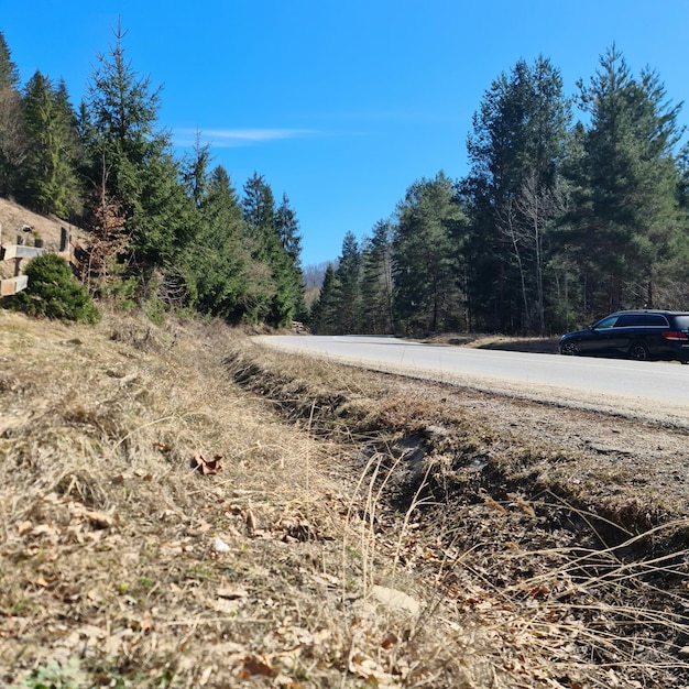 A road with a car on it and a house on the side.