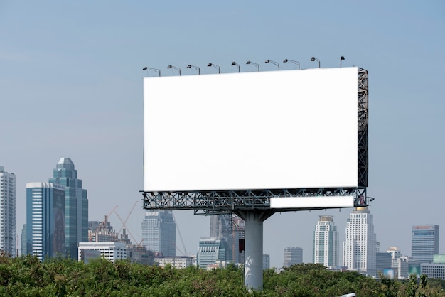 Road with lanterns and large blank billboard at evening in city 