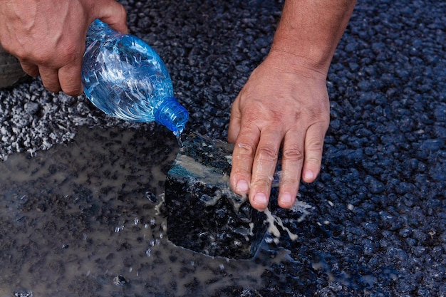 Road workers take a cube of asphalt