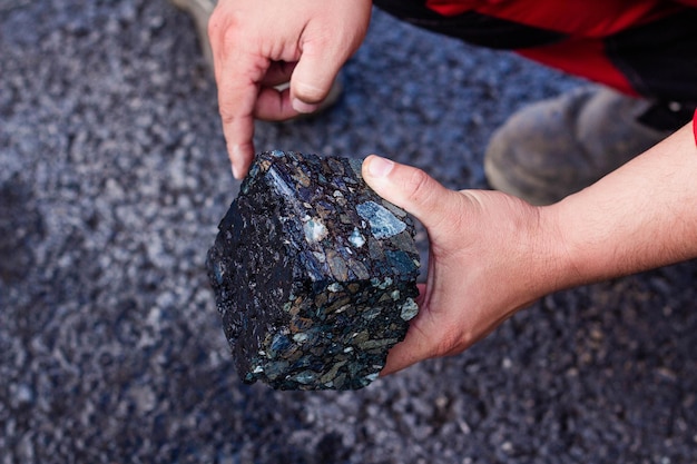 Road workers take a cube of asphalt