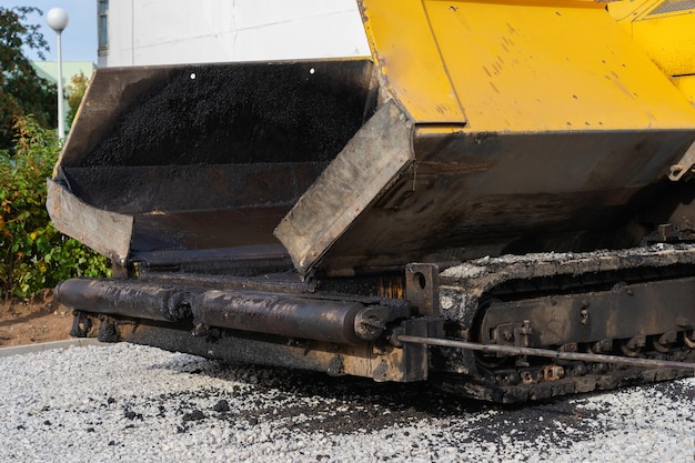 Road works, tracked vehicle for laying asphalt on the road surface