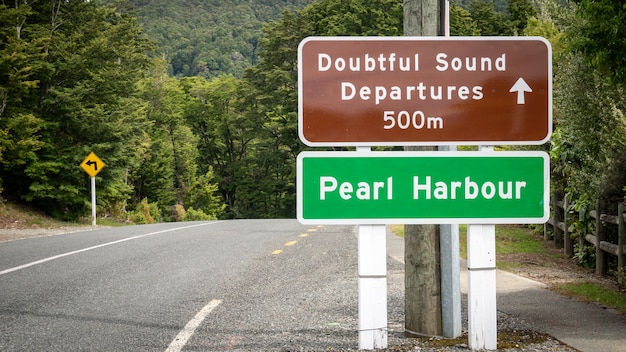 Roadsign on the side of the road reading doubtful sound and pearl harbour new zealand