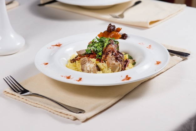 Roast beef and gravy with savory rice, mixed vegetables and herbs served at a restaurant table for a delicious dinner