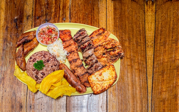 Roast beef with rice fried cheese and tomato salad Nicaraguan food served on wooden table