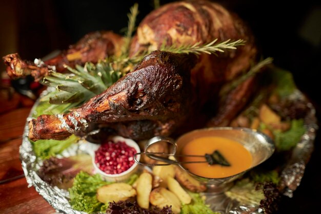 Roast goose stuffed with baked apples in a skillet on a dark wooden background