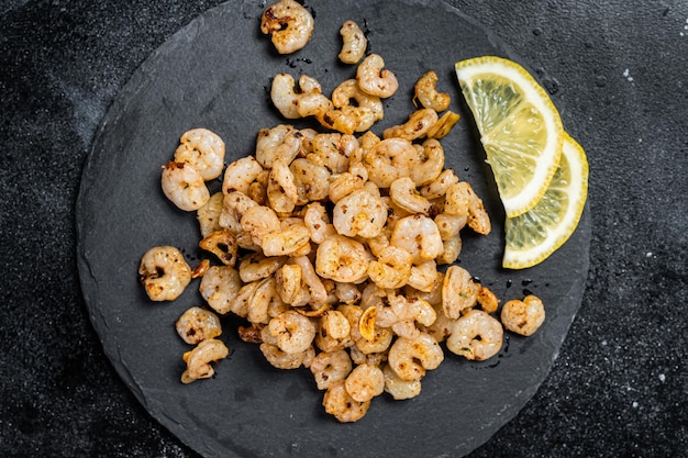 Roast peeled Shrimps prawns with garlic and olive oil Cocktail shrimps Black background top view