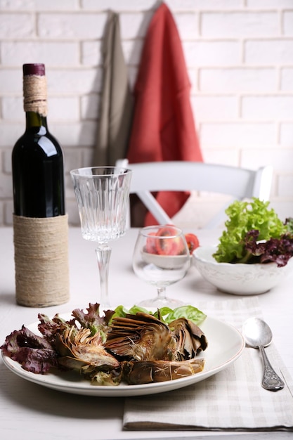 Roasted artichokes on plate on kitchen table background