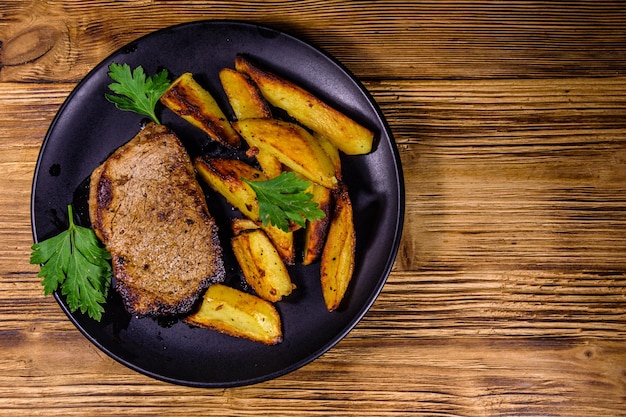 Roasted beefsteak with the fried potato and parsley. Top view