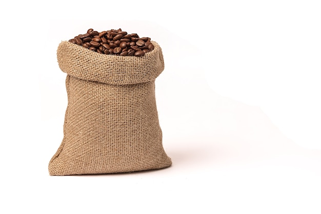 Roasted brown coffee beans. In a burlap sack. On white background. Close-up.