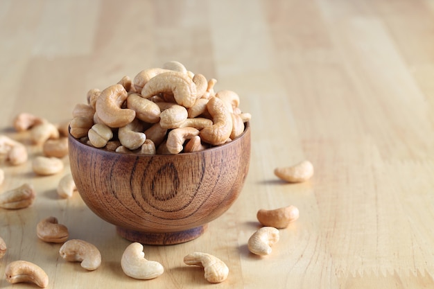 Roasted cashew nuts in a bowl on wooder background, Healthy eating concept