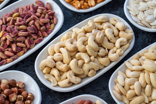 Roasted cashews in selective focus Types of nuts found in bulk on a dark background Top view nuts