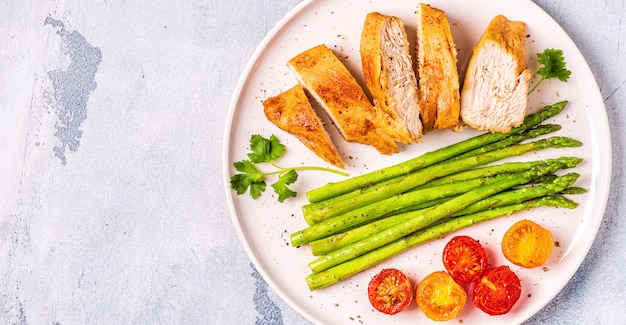 Roasted chicken breast with asparagus and tomatoes