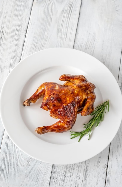 Roasted chicken on the white serving plate