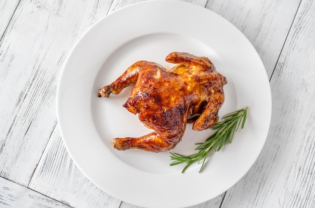 Roasted chicken on the white serving plate