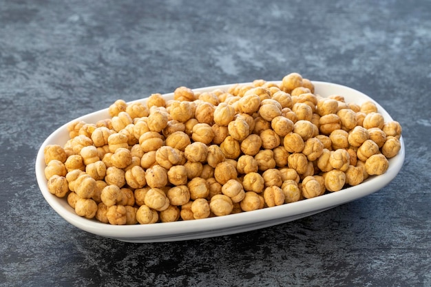 Roasted chickpeas on plate on dark background