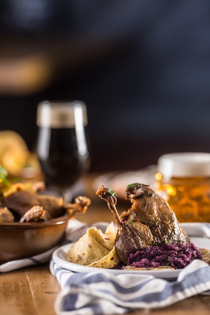 Roasted christmas duck leg red cabbage dumplings liver draft beer and baked buns.