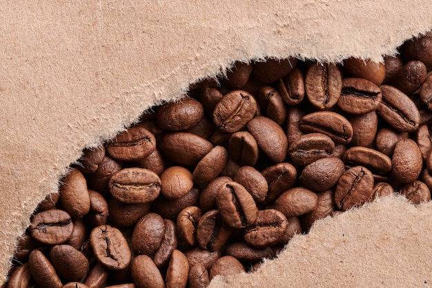 Roasted coffee beans decorated with kraft paper closeup creative background