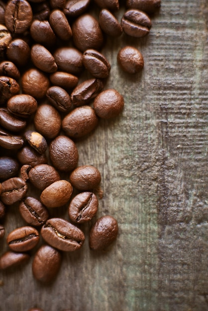 Roasted coffee beans on rustic wooden background. Food ingredients, top view