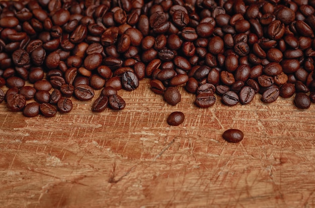 Roasted coffee beans in selective focus on wooden table