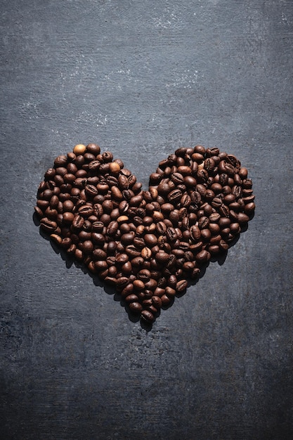 Roasted coffee beans in the shape of a heart on a gray background love coffee