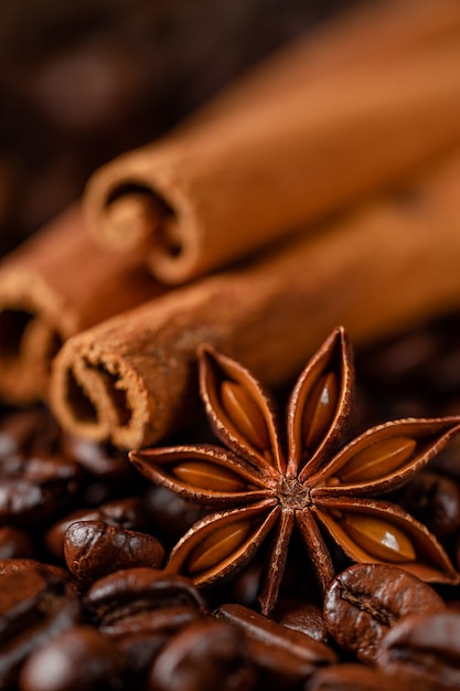 Roasted coffee beans and spices background. Macro shot, vertical