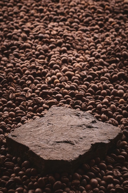 Roasted coffee beans on stone pedestal brown background