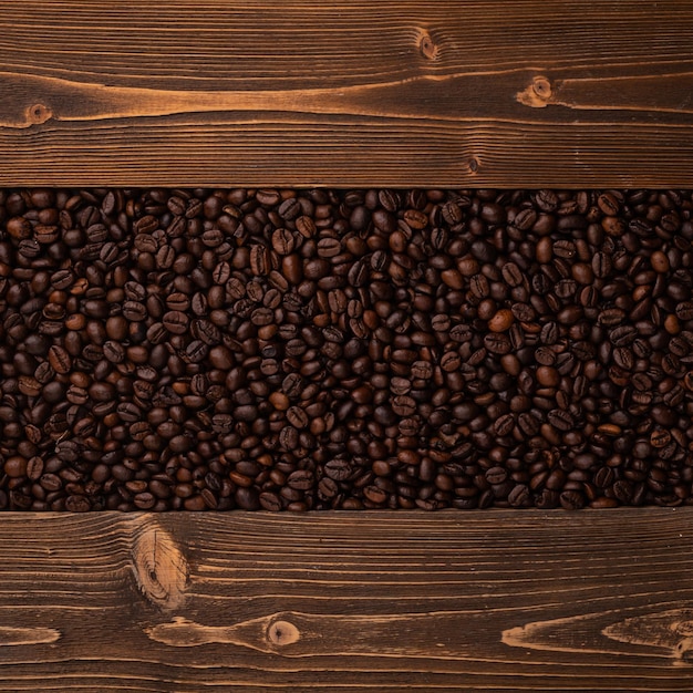 Roasted coffee beans and wooden texture Top view brown coffee beans texture for backdrop and wallpaper use