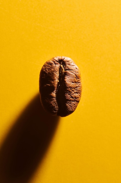 Roasted coffee beans on yellow background