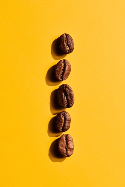 Roasted coffee beans on yellow background