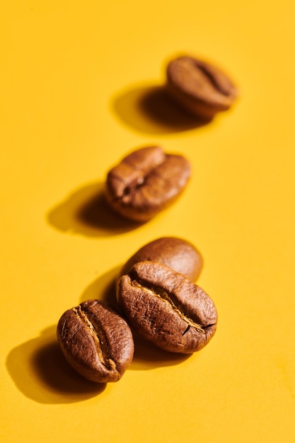 Roasted coffee beans on yellow background