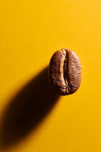 Roasted coffee beans on yellow background