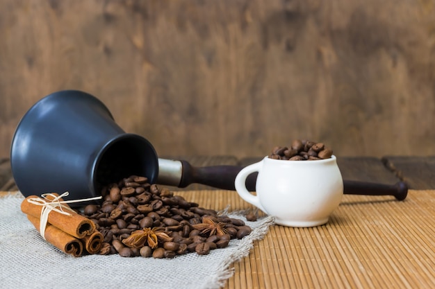 Roasted coffee from the Turks scattered on a linen napkin next to the star anise and cinnamon