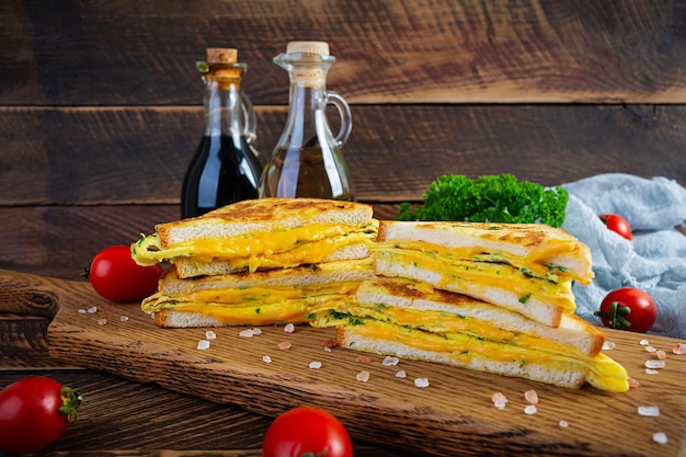 Roasted French toast with ham, egg, herbs and cheese cheddar. Delicious grilled breakfast sandwich