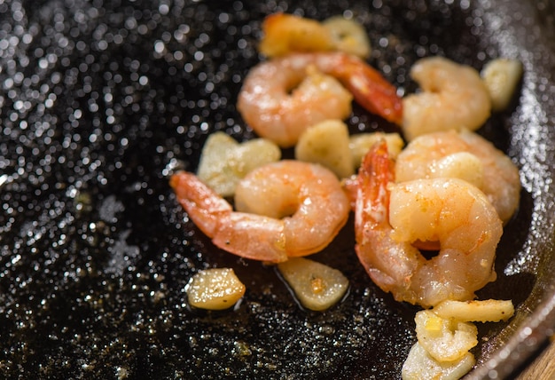 Roasted king prawns with garlic on a castiron frying pan