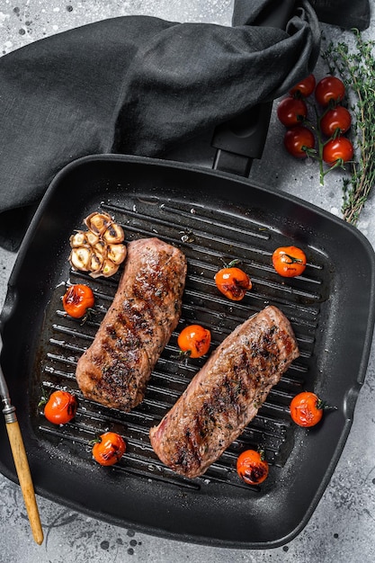 Roasted Lamb tenderloin fillet meat on grill pan mutton sirloin steak Gray background Top view