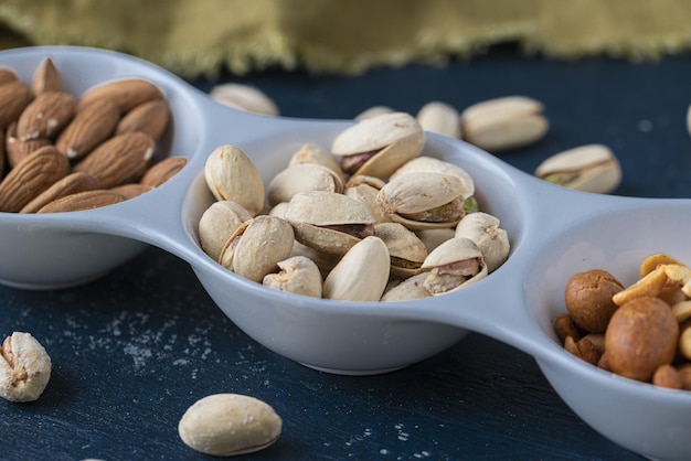 Roasted Nuts And Salted Pistachios In White Ceramic Bowl