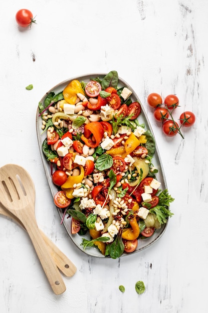 Roasted pepper and butter bean salad with harissa dressing on white background