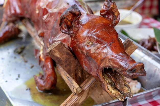 Roasted pig on the traditional barbecue Grilled pig on the market of Bali Indonesia closeup