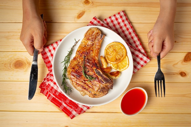 Roasted pork steak on wooden surface.